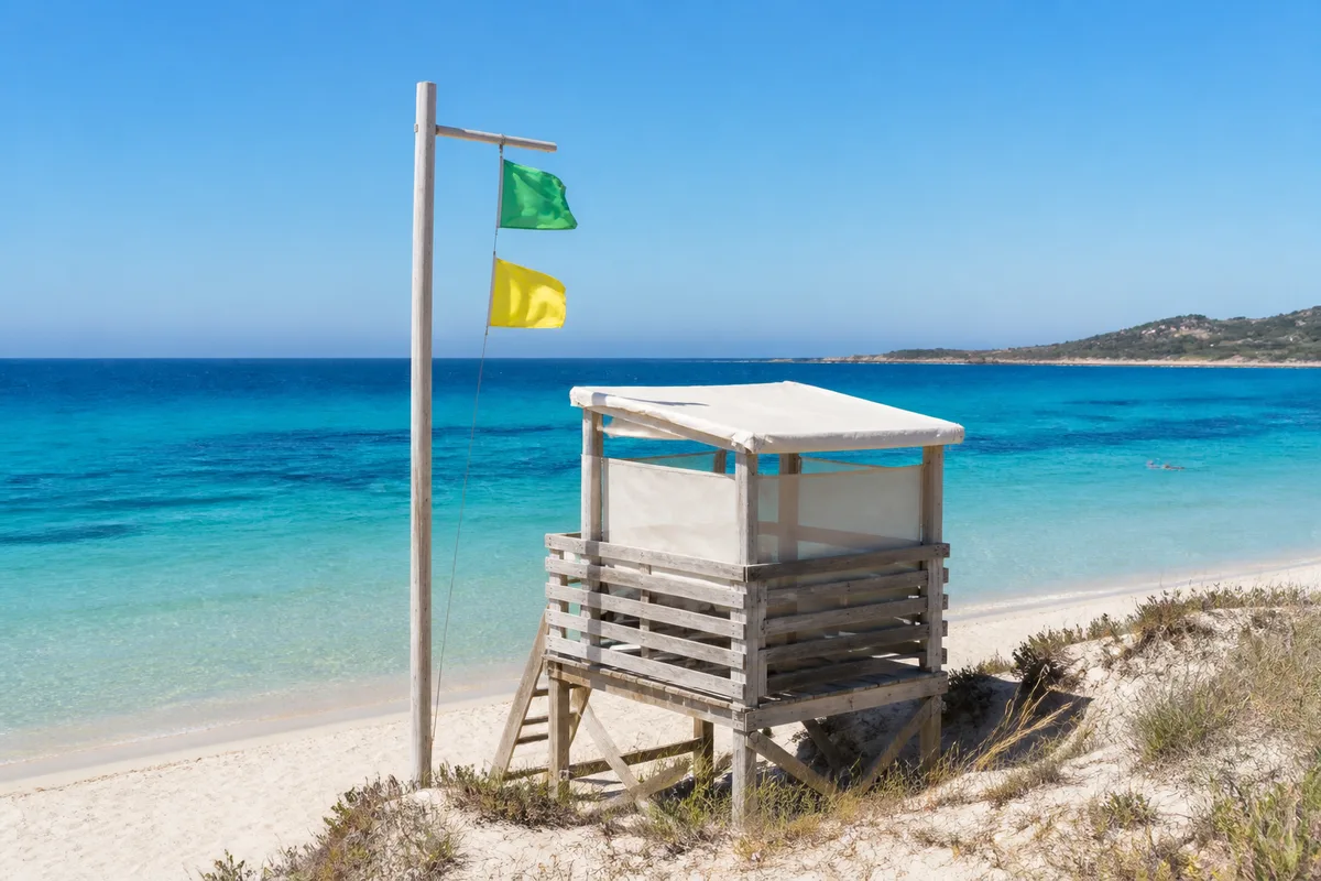 Poste de surveillance de plage avec mât de signalisation face à la mer